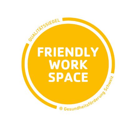 The logo of the Friendly Workspace label is composed of a yellow circle. In the center, Friendly Work Space is written in white letters and at the edge it says that it is a seal of quality of Health Promotion Switzerland