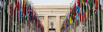 The façade of the Palais des Nations in Geneva with flags.