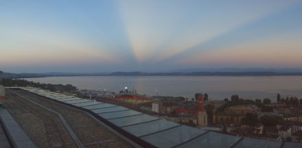 A view over a lake, with anti-crepuscular rays spreading out over it and disappearing over the horizon.
