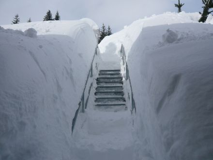 Photo of the snow measurement field entrance in San Bernardino, surrounded by snow walls. 