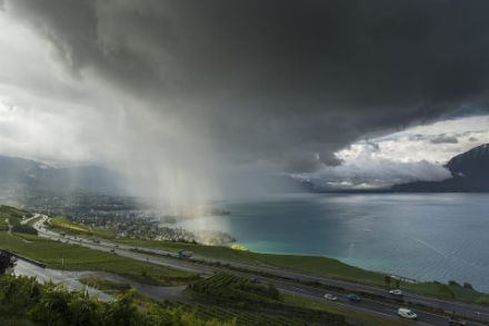 	In the centre of the image, individual rain-shower clouds can be seen on the shores of Lake Geneva