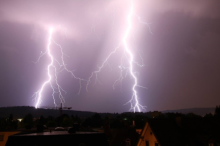 Two bright flashes of lightning illuminating the night sky.