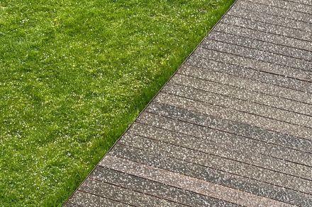 Grass and a wooden walkway speckled with sleet.