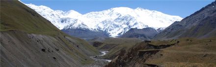 Snow covered Central Asian mountains with valley and river